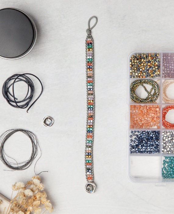 A beading kit with a variety of beads on a table.