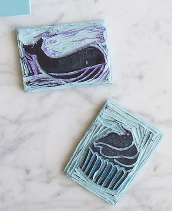 Two blue and white rubber stamps with a whale on them.